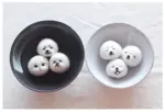 DIY kawaii diy kit: Felt roly poly rice balls with faces in ceramic bowls.