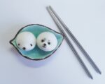 DIY kawaii diy kit featuring two cute rice balls with eyes, served in a small bowl.