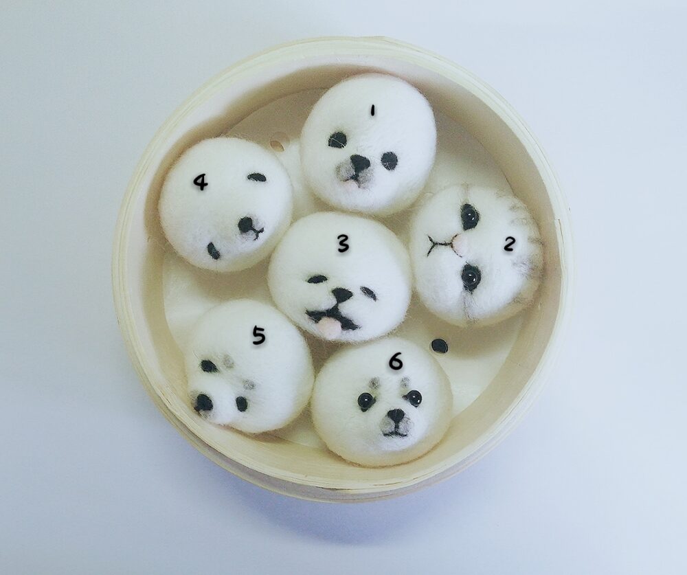 DIY kawaii diy kit: Assorted panda-shaped rice balls with faces, in a bamboo steamer.