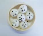 DIY kawaii diy kit: Assorted panda-shaped rice balls with faces, in a bamboo steamer.