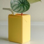 Kawaii juice box flowerpot featuring a small plant and straw. 3D printed resin design.