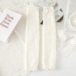 White knitted gyaru socks with a bow detail, showcasing a kawaii aesthetic.