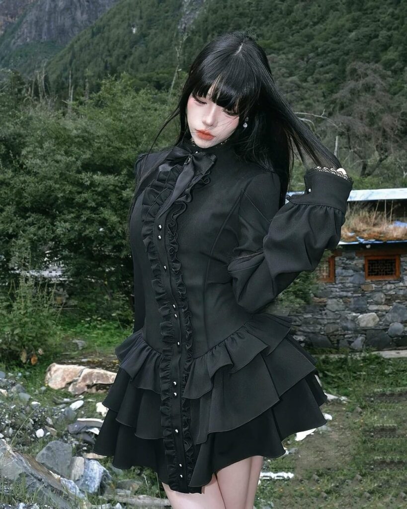 Black laced gothic lolita dress with ruffled details, featuring a long-sleeved blouse and layered skirt.