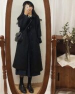 Woman wearing a black Korean style coat, mirror reflection.