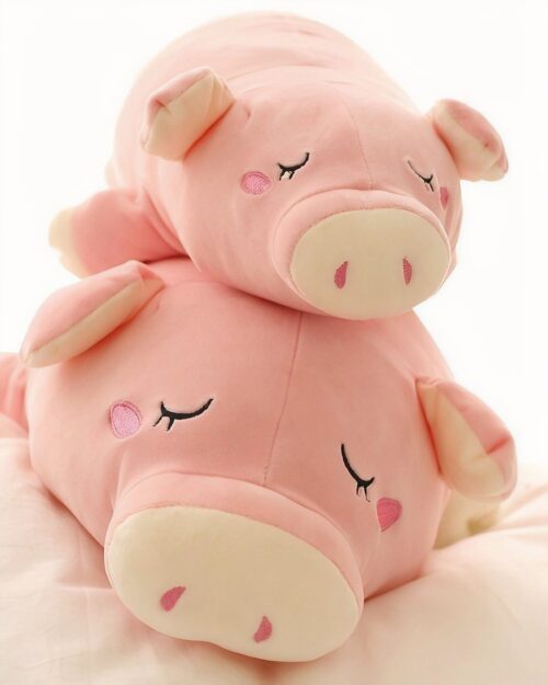 Close-up of a pink kawaii piggy plushie with embroidered eyes and snout.