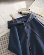 Close-up of a blue ethno-chic hoodie featuring embroidered details and a drawstring hood.