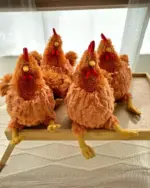 Set of plush fat chicken toys on a bamboo tray. A cute fat chicken plushie.