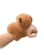 Brown capybara plushie bracelet on a hand. Cute, soft toy.