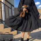 Black gothic lolita dress with ruffles, worn by a person outdoors.