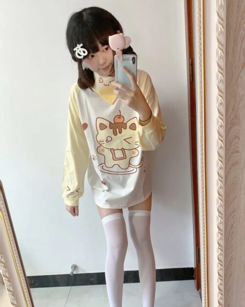 Model wearing a yellow pudding cat shirt with cute illustrations.