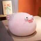 A pink pufferfish plush toy, soft and stuffed, displayed on a table.