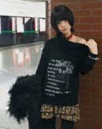 Off shoulder dark pullover grunge aesthetic sweater worn by a model.