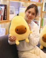 A cute kawaii avocado plushie being held by a woman.