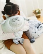 Yuki the seal plush resting in a person's arms, showcasing its soft texture and design.