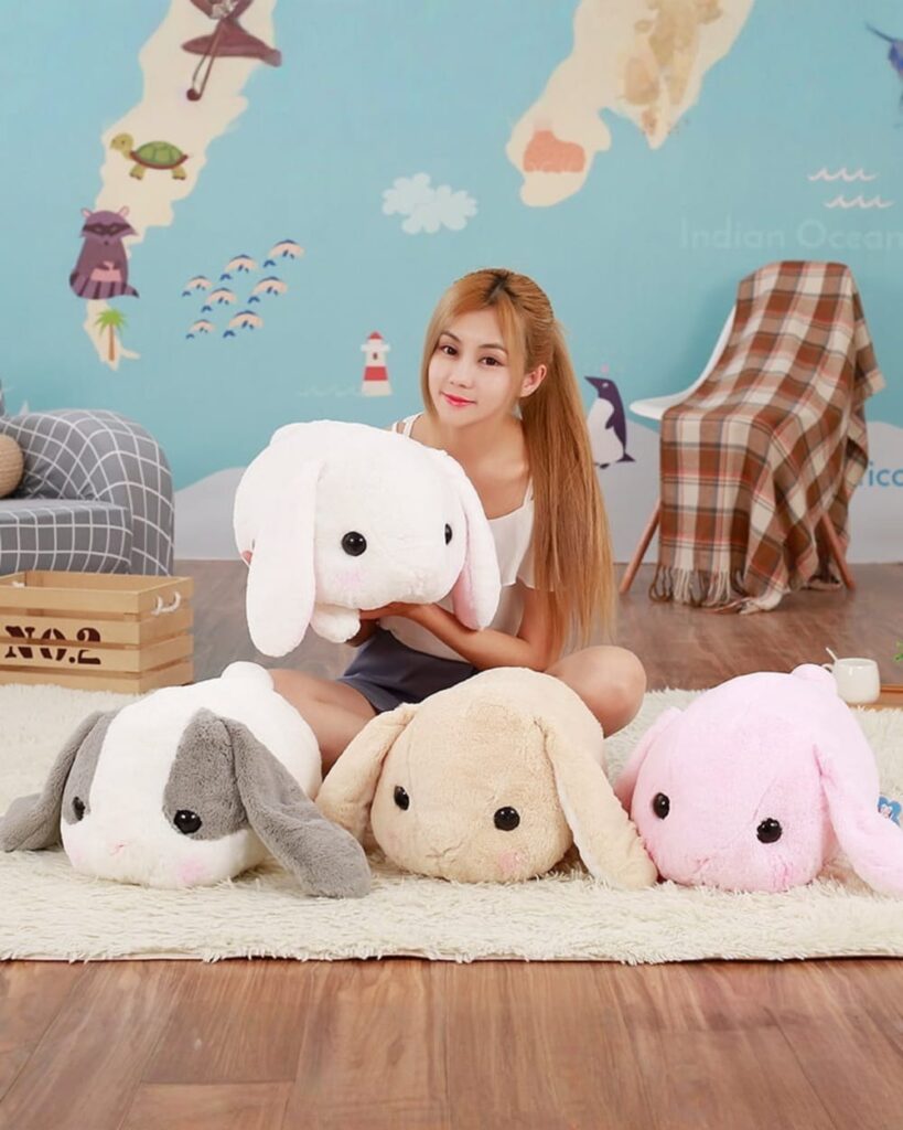 A set of big bunny plushies in white, pink, gray, and beige. Soft, floppy stuffed animals.
