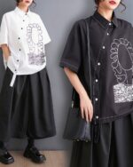 Two women wearing a retro aesthetic shirt with floral and graphic design details. The shirt features a short-sleeve design.