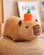 Brown capybara plushie with a carrot on its head, soft stuffed animal.