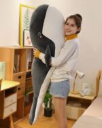 Large kawaii whale plushie held by a woman, soft and cuddly toy.