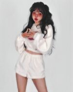 Model wearing a white kawaii fluffy pajamas set, featuring a hooded jacket and shorts.