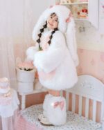 Child wearing an Easter bunny costume, featuring a fluffy white outfit and pink accents.