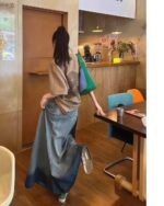 Woman wearing a blue y2k aesthetic skirt and a casual top, walking indoors.