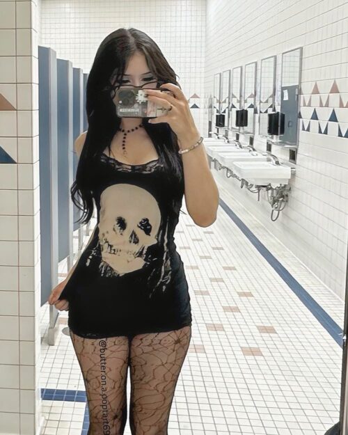Model wearing a black gothic aesthetic dress with a large skull print.