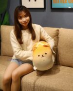 Kawaii Melonwan plushie resting on a couch with a person.