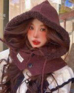 Close-up of a maroon korean balaclava hat with a hood and button detail.