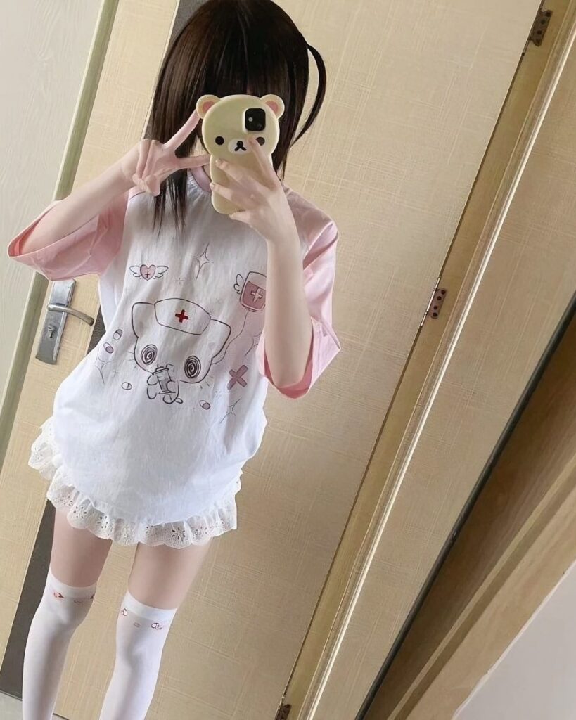 Pink neko nurse t-shirt worn by someone, featuring a nurse and animal print design.