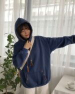 Blue ethno-chic hoodie with embroidered details and a drawstring hood.