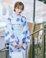 Woman wearing a blue japanese yukata with floral print, summer kimono style.