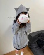 Kawaii cat paw hoodie featuring cat prints and a cat plushie.