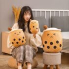 Cute bubble tea plushies, featuring a girl holding two plush drinks with tapioca pearls.