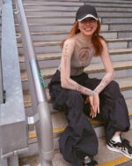 Mesh pattern witchcore long sleeve top worn by a woman on stairs.