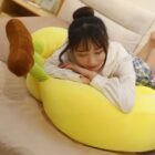 Cute yellow banana plushies in a three-pack, resting on a bed.