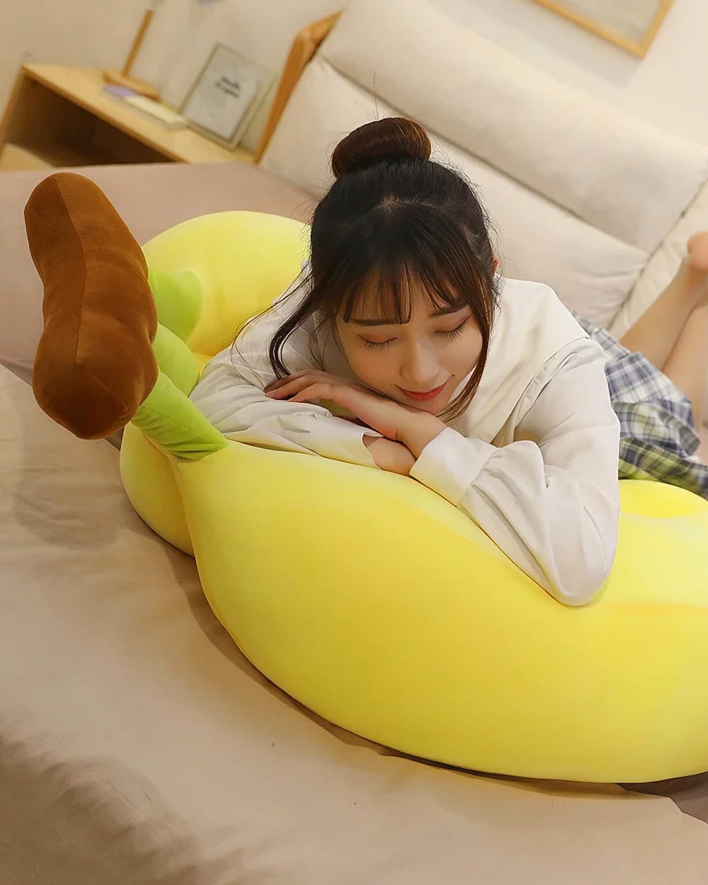 Cute yellow banana plushies in a three-pack, resting on a bed.