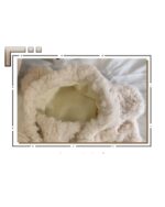 Close-up of a fluffy bear ear hat, featuring a soft, beige exterior and inner lining.