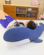 Blue kawaii whale plushie resting on a bed, soft and cuddly.