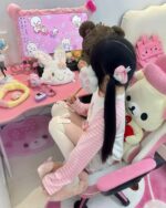 Person wearing a kawaii striped shirt with plush toys and a themed backdrop.