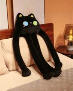 Black long-legged bear plushie resting on a bed, soft and cuddly.