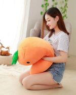 Close-up of a kawaii carrot plushie, soft and orange, held by a person.