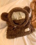 Fluffy brown bear ear hat with pom-poms and a soft lining.