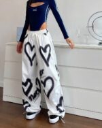 White y2k aesthetic pants with graffiti print, high waist loose fit.