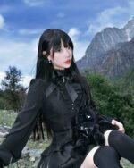 Black laced gothic lolita dress worn by a model outdoors.