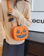 Cute orange pumpkin halloween bag with a smiling face and strap.