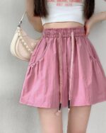 Pink Korean aesthetic shorts with drawstring and pockets. Casual elastic design.
