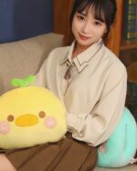 Round animal hand warmer plushie, yellow duck with green accents, soft and cuddly.