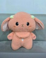 A plush toy, kawaii space sheep plushie, featuring soft pink fur and golden horns.