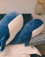 Blue and white kawaii whale plushie on a bed, soft and cuddly.