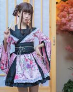Model wearing a pink and black harajuku aesthetic kimono with floral details and lace trim.